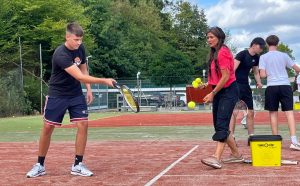 Das Bild zeigt einen Schüler beim Tennisspielen.