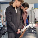 O. Koch zeigt seinen Schülern das Innenleben eines LAutsprechers.