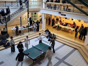 Schülerinnen und Schüler sind beim Tischtennisspielen zu sehen.