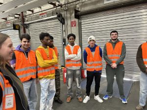 Das Bild zeigt die Schülerinnen und Schüler der Klasse 25LGB im Lager der  Firma ELSEN.